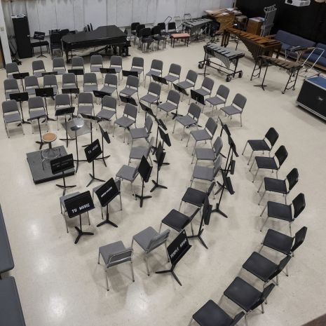 Chairs and music stands set up in three semi-circles 