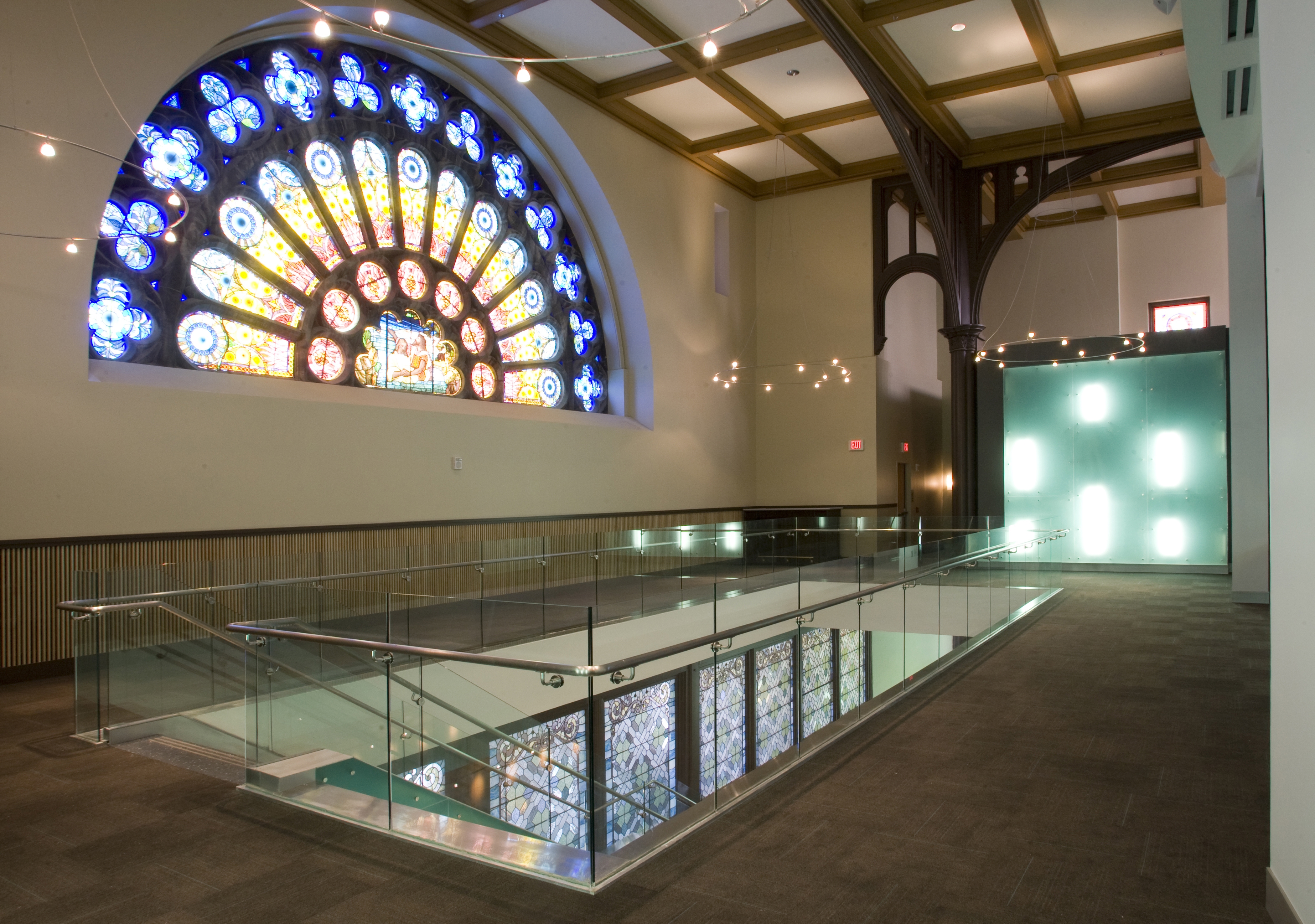 Performance hall second floor lobby with large stained glass window