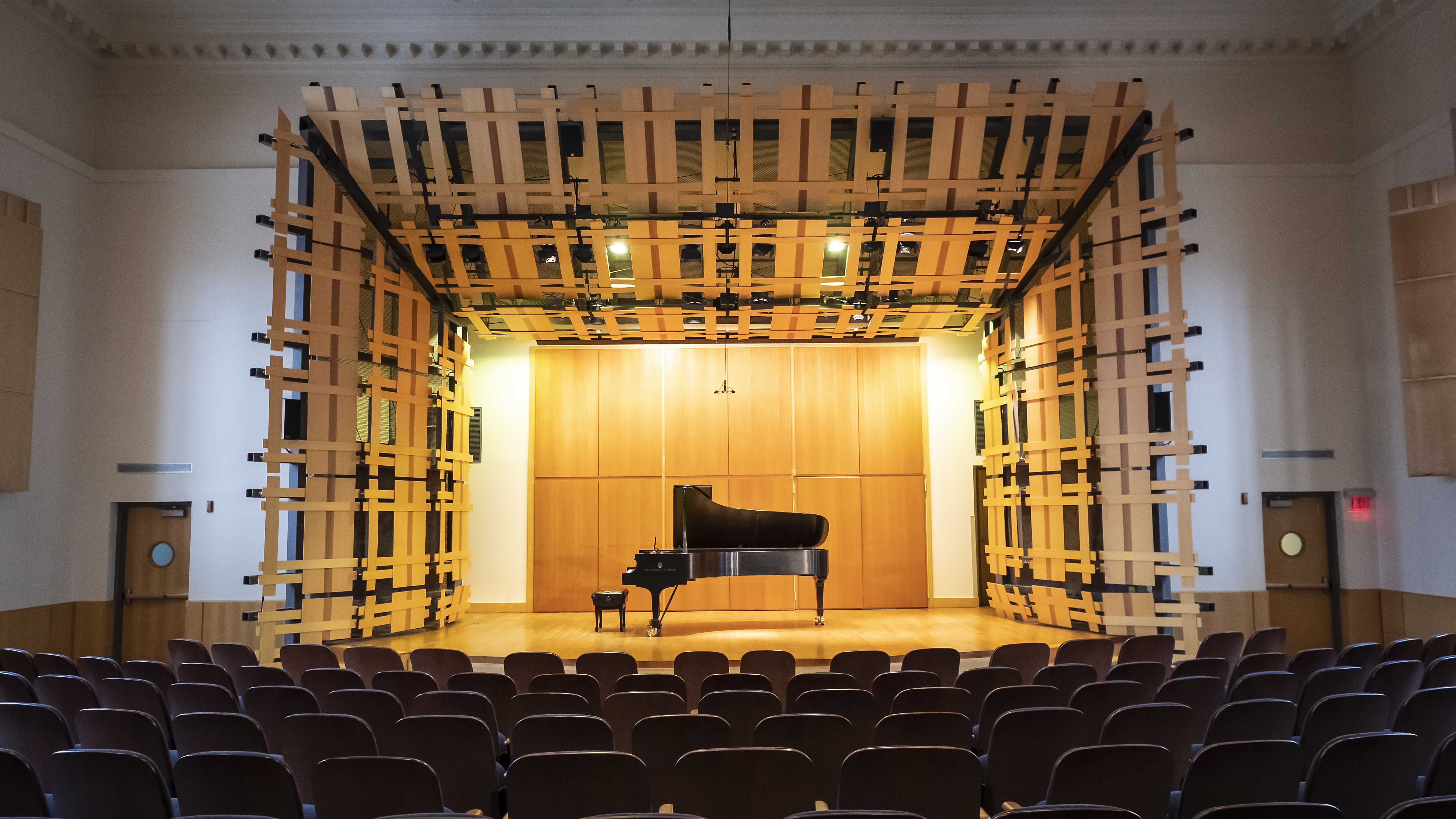 Auditorium seating and stage with grand piano, from the back of the hall