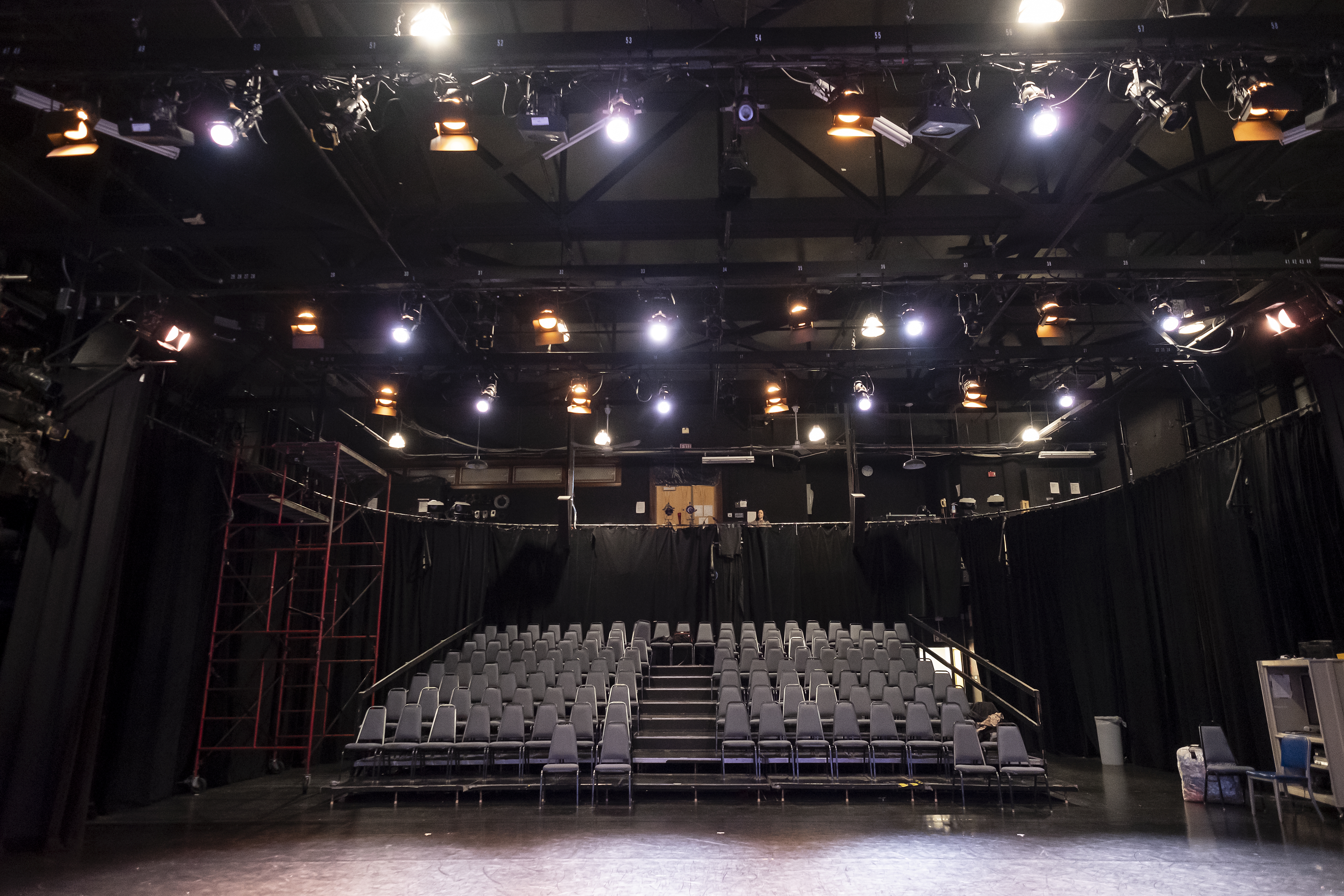 Black box theater seating with stage lights above 