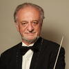 Man in tuxedo holds conductors baton