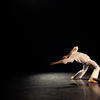 male solo daner in a back bend with arm reaching behind them