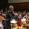 Man conducting a student string ensemble