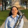 Sarah Connors standing on a sidewalk, holding a clarinet