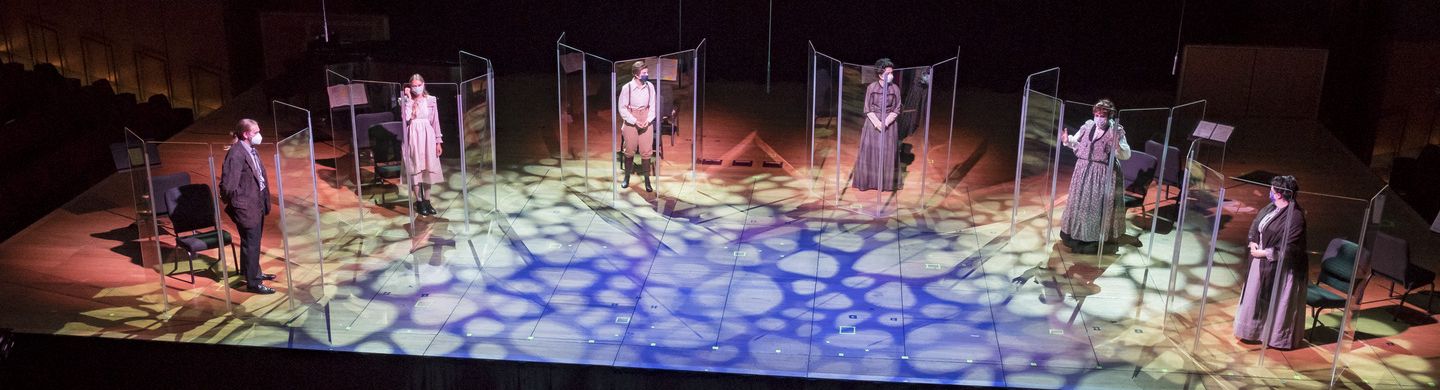 Photo of individual singers behind plexiglass being conducted on TPAC stage