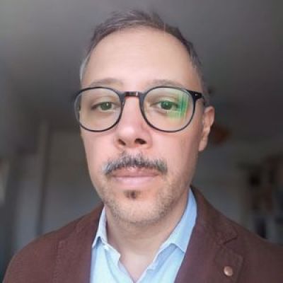 Portrait photo of a man with gray hair and glasses