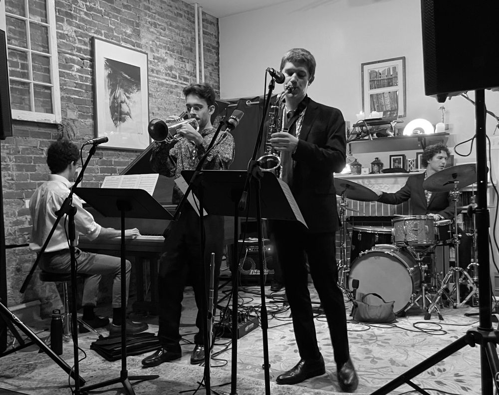 Black and white photo of musicians playing in a cozy space