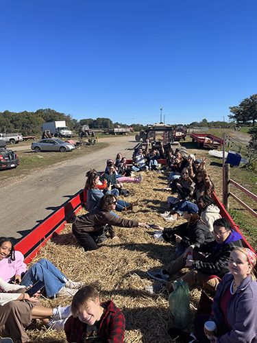 College students on a hayride at Linvilla Orchards on a beautiful fall day with blue skies.