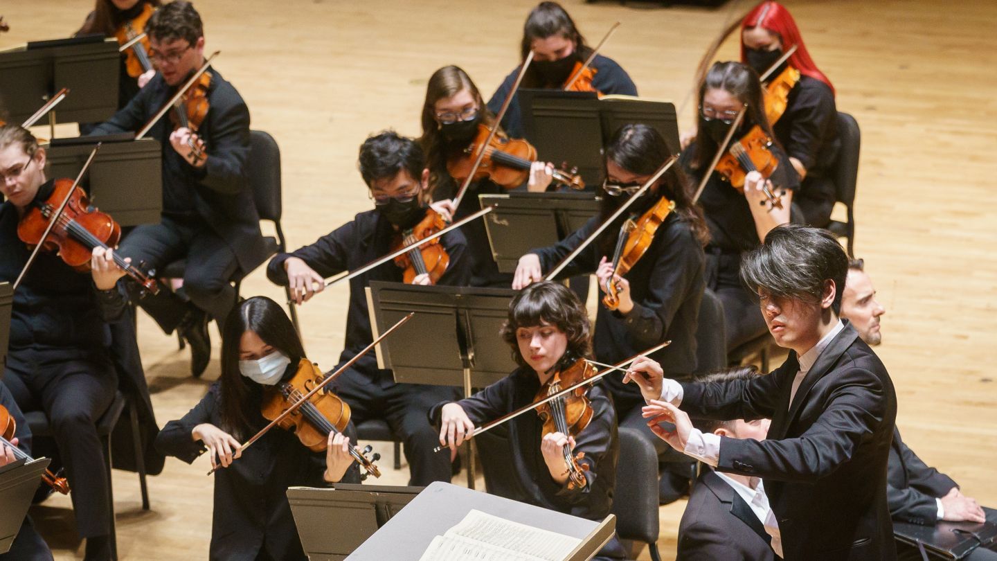 Image of the Temple University Symphony Orchestra violins being conducted by Kensho Watanabe
