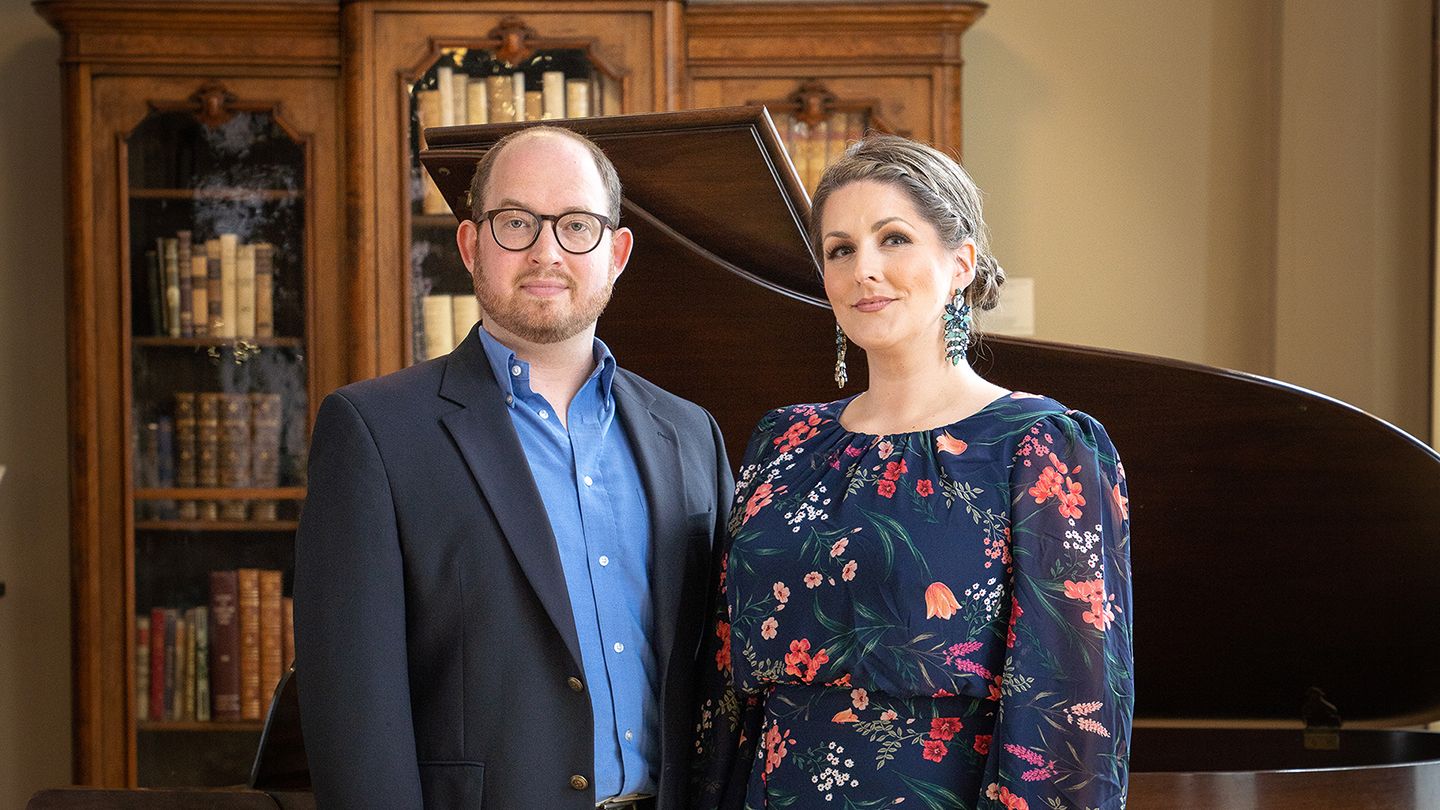 Samuel Martin and Kathryn Leemhuis stand together in front of an open grand piano.