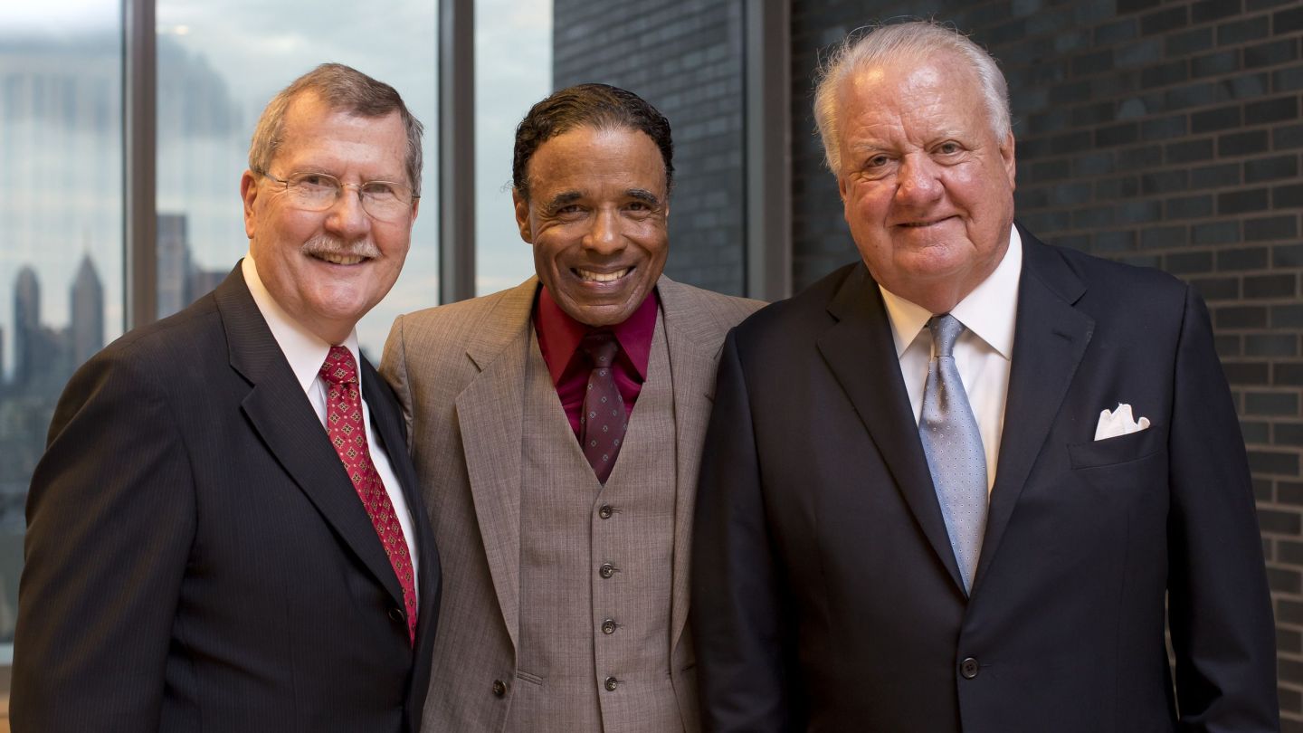 Three men standing and smiling together