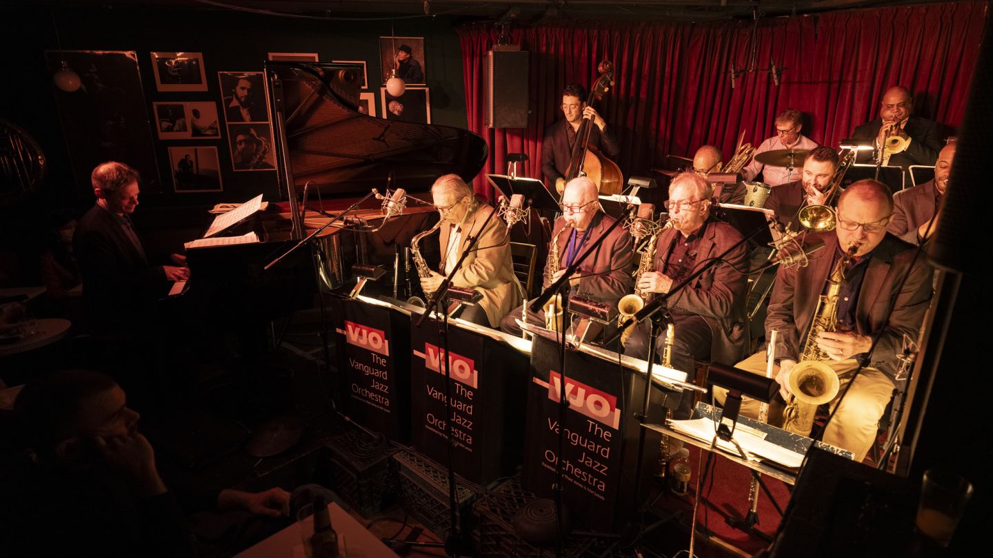 Photo of the Vanguard Jazz Orchestra performing in a dark venue
