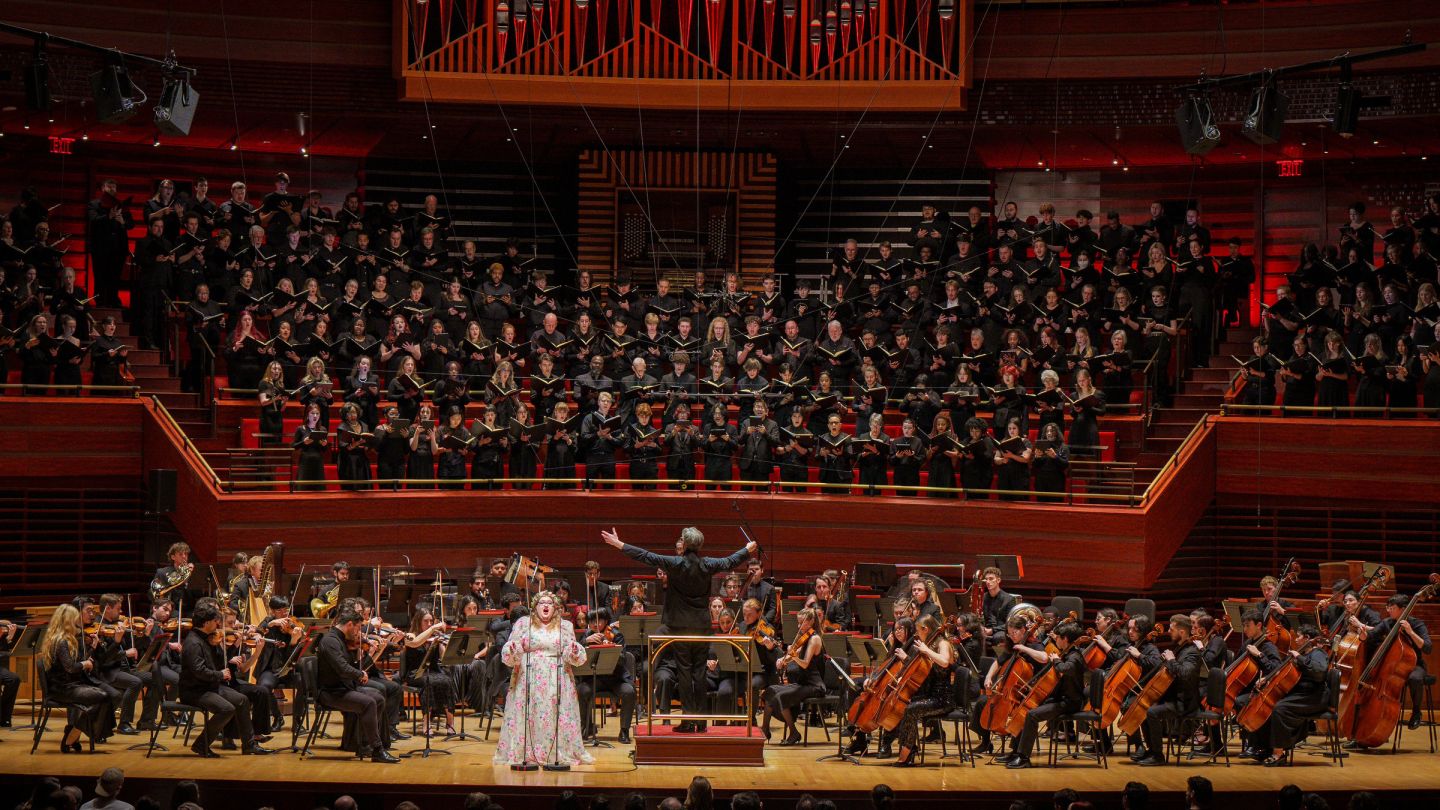 Orchestra and choirs performing in a large concert hall